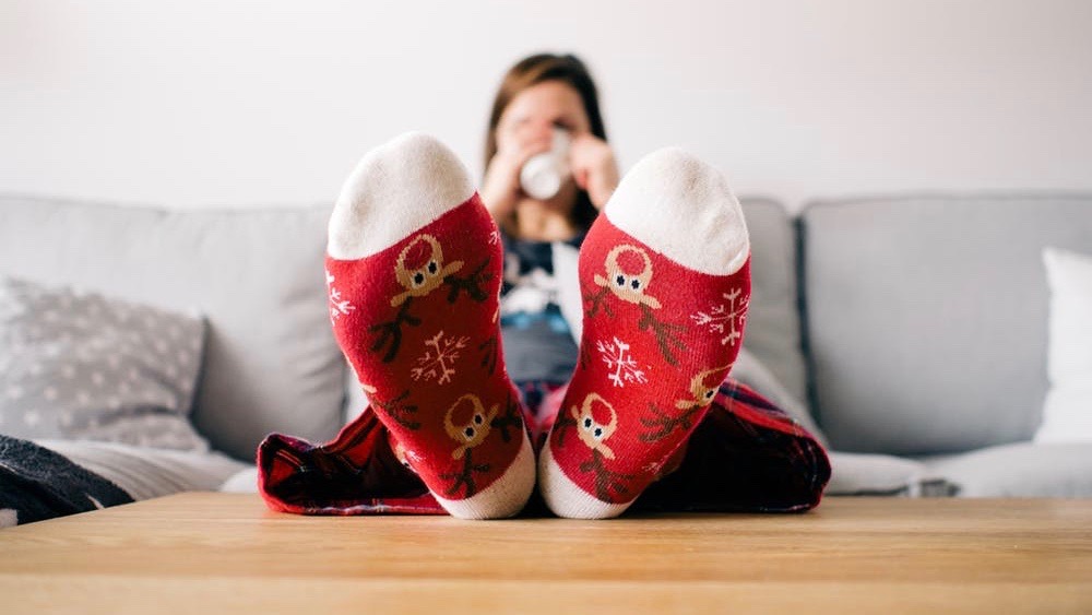 A woman rests her feet on a coffee table.