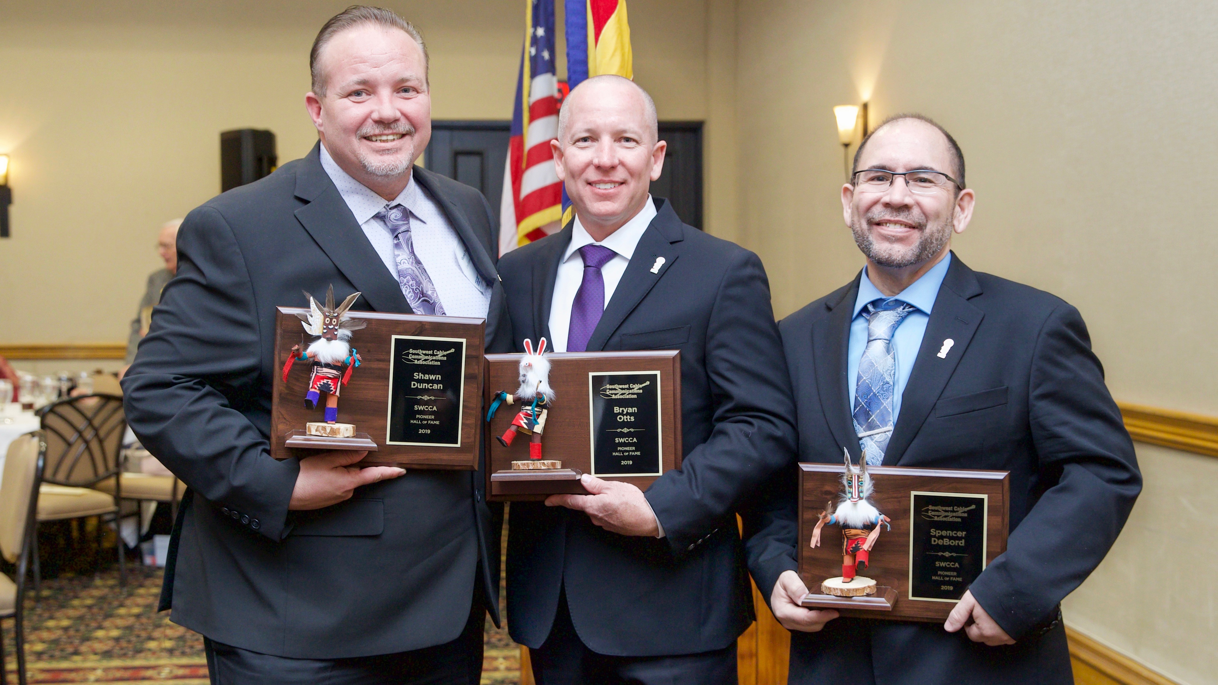 Southwest Cable Communications Association Hall of Fame inductees stand together as they hold their awards.