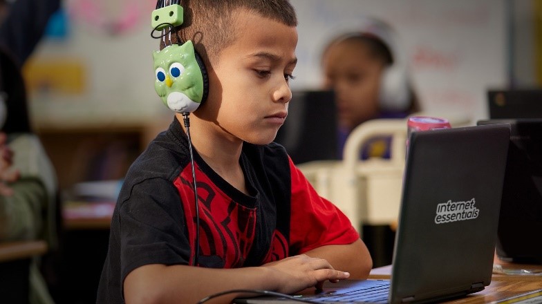Student using a laptop with Internet Essentials branding